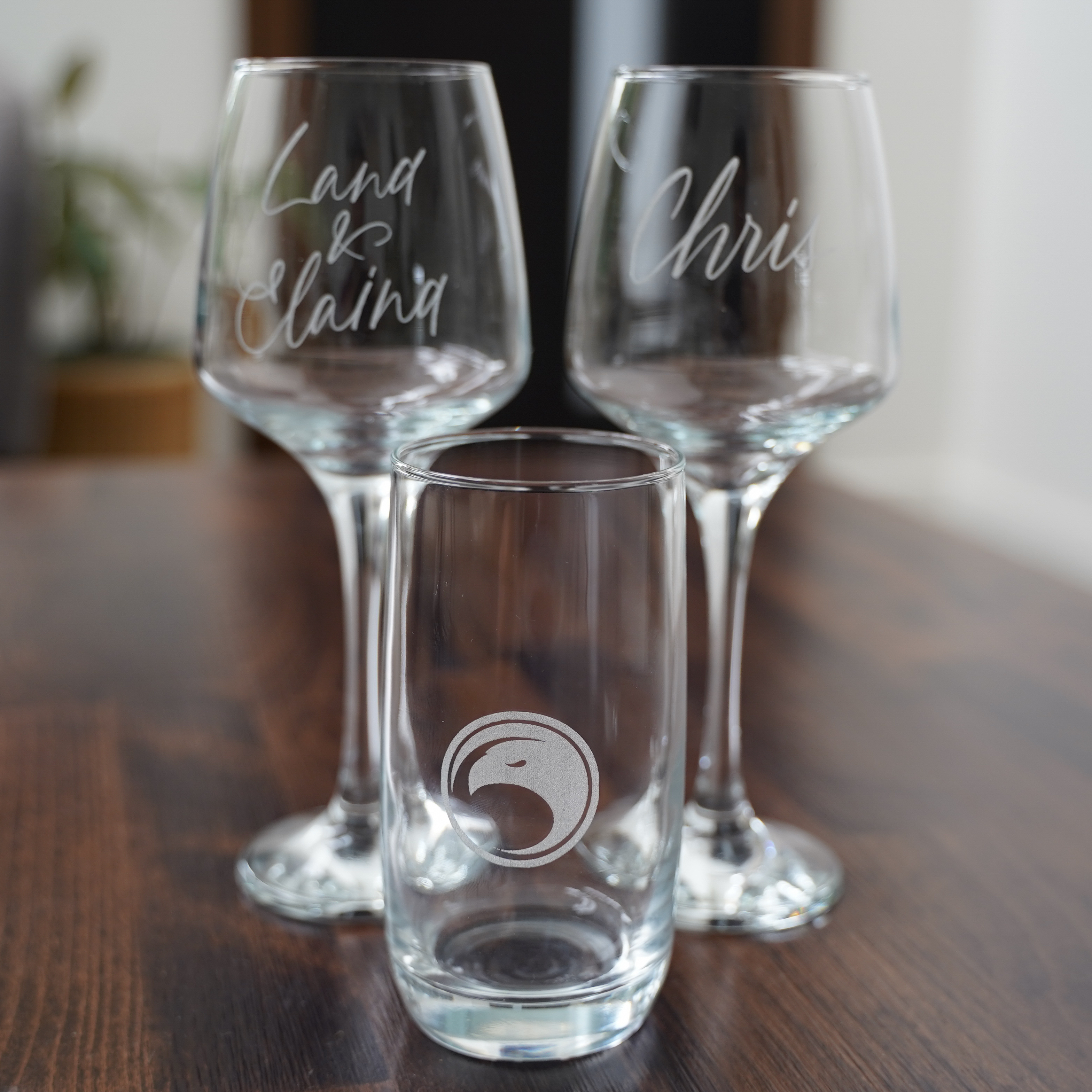 et of personalised glassware featuring engraved logos and hand-lettered names, perfect for events