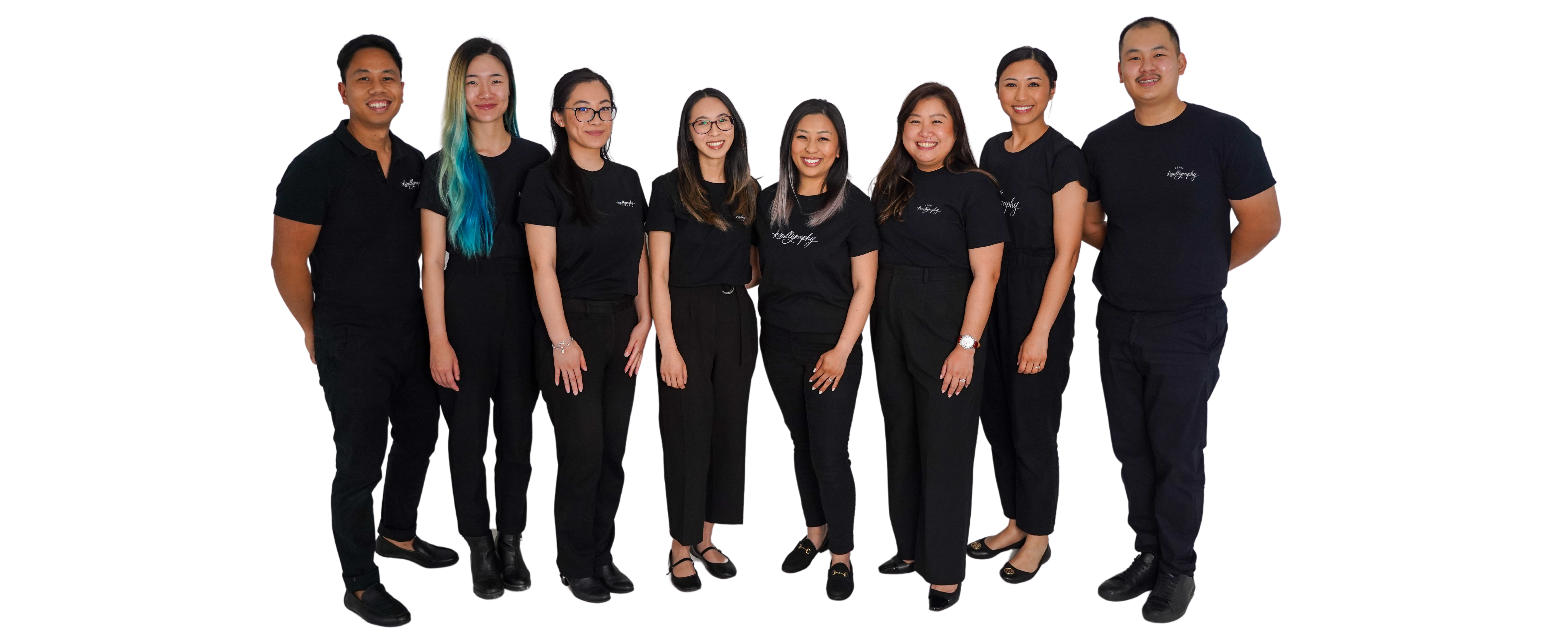 The Kimlligraphy team posing together in branded black t-shirts, showcasing their diverse group of calligraphers, lettering artists, and engravers