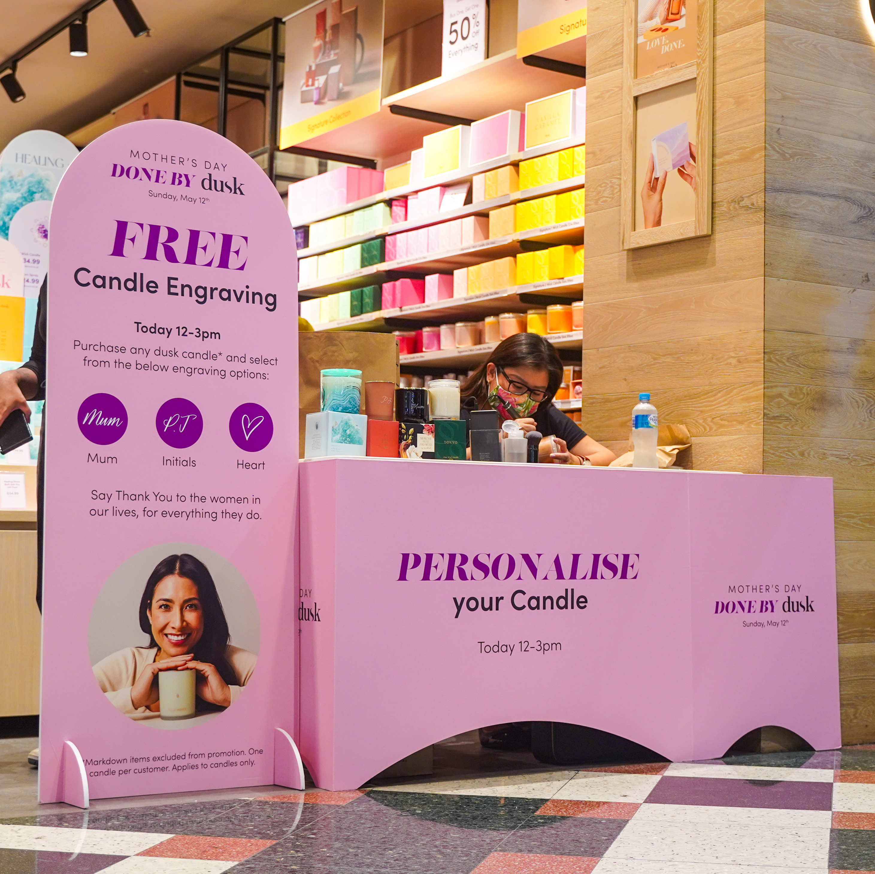 In-store candle engraving station with vibrant signage offering personalised services, creating a unique customer experience
